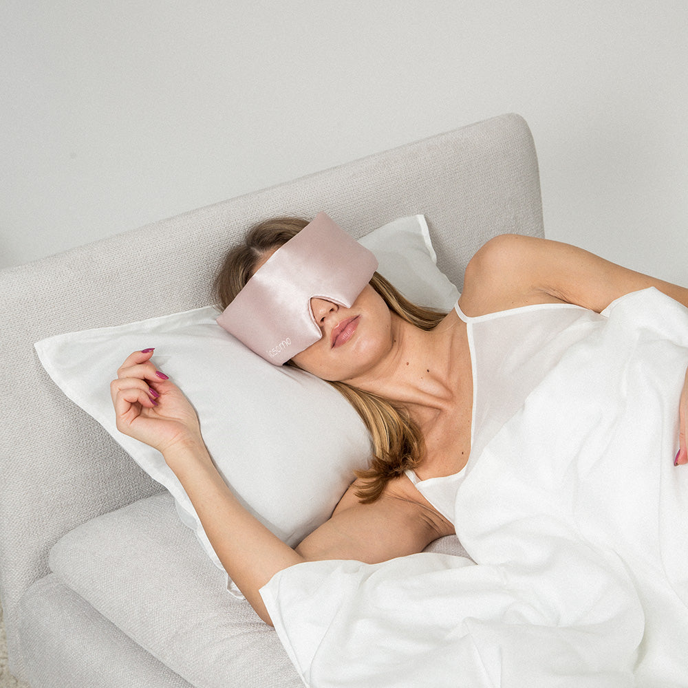 Woman sleeping with a pink silk sleeping mask