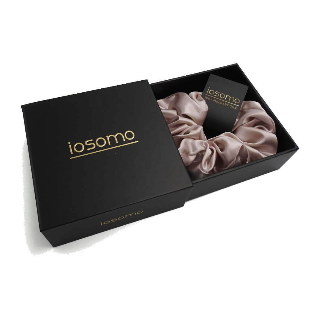 iosomo packaging with a pink scrunchie inside on a white background